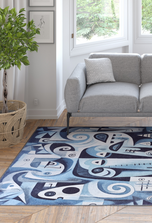 Load image 1 in gallery view. A modern living room with a light gray sofa, polka dot pillow, potted plant, light wood floors, abstract wall art, and the Aesthetic Anomaly Contemporary Washable Rug - MDJ004—a blue rug with stylized faces, ideal for high-traffic areas.
