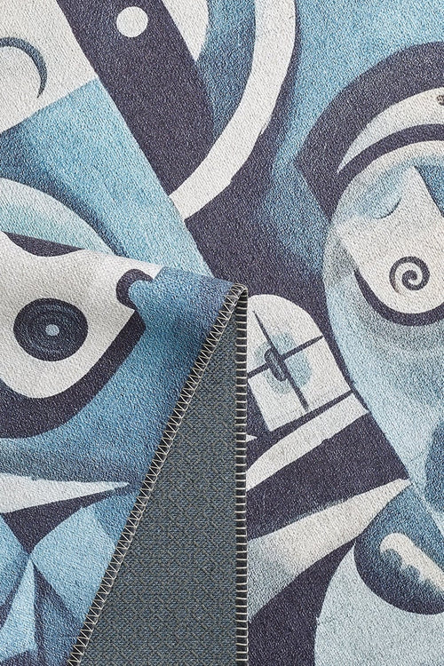 Load image 1 in gallery view. A close-up of the Aesthetic Anomaly Contemporary Washable Rug - MDJ004, showcasing its blue and white abstract geometric face pattern and stitched edge with a folded corner revealing the textured underside—ideal for high-traffic areas.