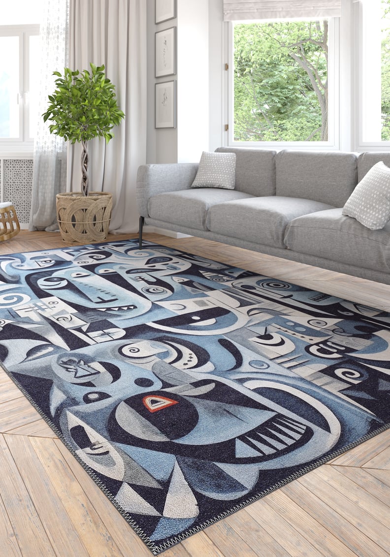 A modern living room features the Aesthetic Anomaly Contemporary Washable Rug - MDJ004 (Custom Size), with geometric and face-like patterns, under a light gray sofa, white pillows, potted plant, and large windows with white curtains.