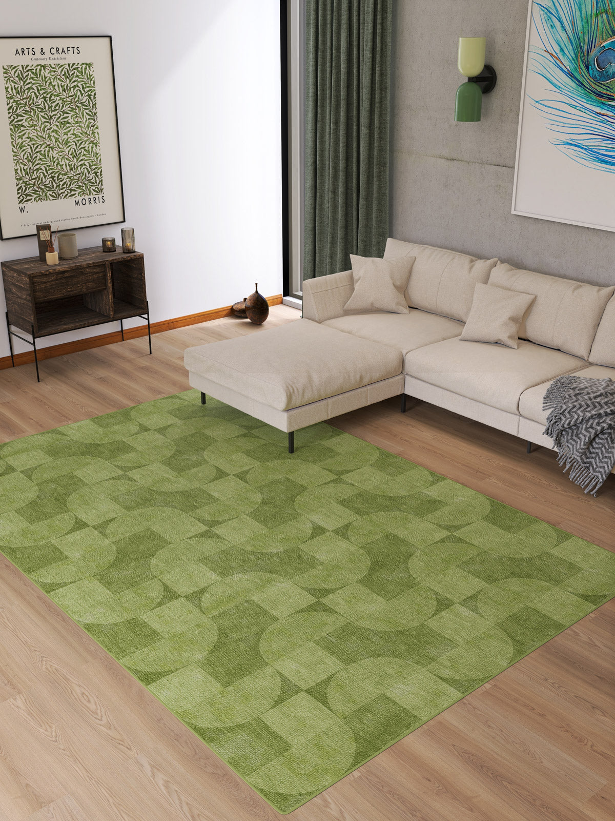A modern living room features a light beige sectional sofa, wooden floor, and the Aged Serenity - Washable Rug - JRN51 with geometric patterns. Wall art, a console table with decor, and green curtains by a large window complete this stylish space.