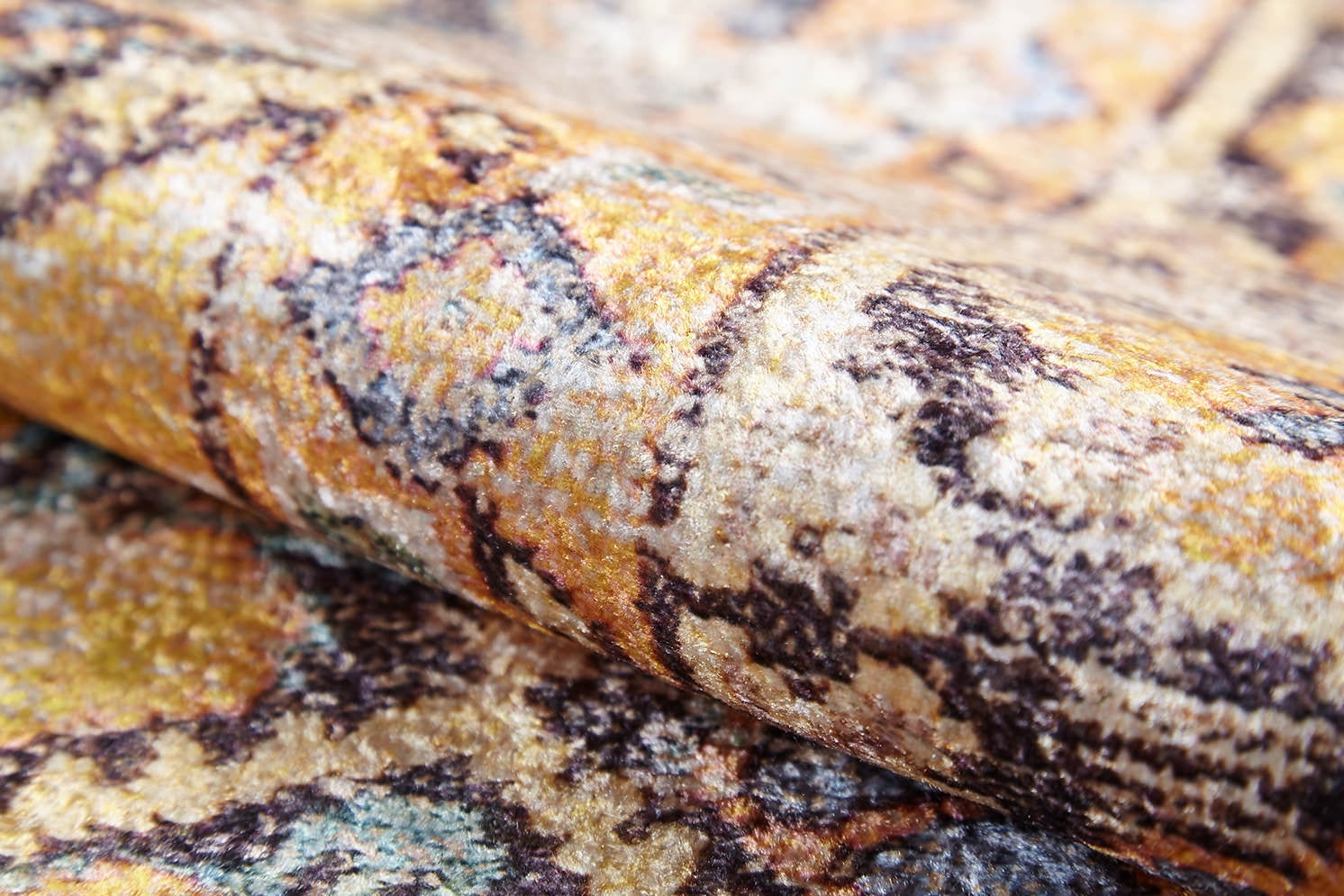 A close-up of the Aged Splendor - Washable Rug - JR1906 (Custom Size) shows its textured surface and intricate yellow-gold, brown, and blue abstract design—perfect for high-traffic areas.