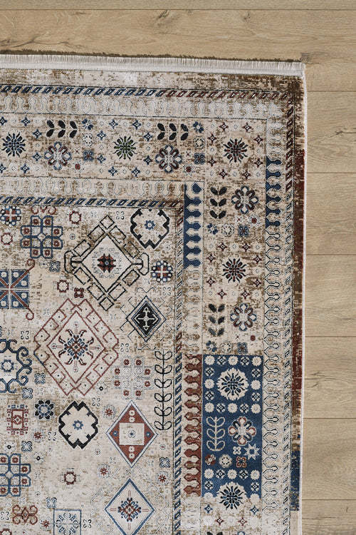 Load image 1 in gallery view. A corner of the Aged Treasures Premium Rug - 2181A featuring machine-made geometric patterns in blue, brown, and cream floral motifs is shown on a light wooden floor.