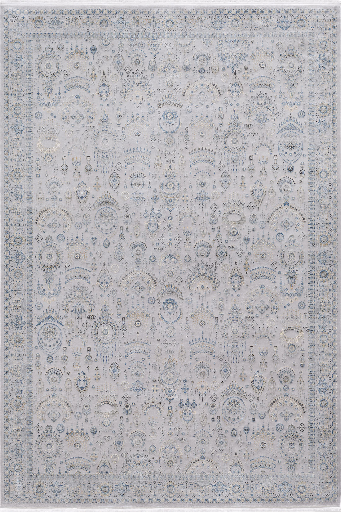 The Ancestral Motifs Turkish Rug - 2225C is a large, rectangular, machine-made rug with an intricate floral and geometric pattern in soft gray, blue, and ivory. It features a decorative border and a faded vintage look.