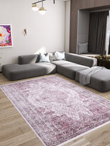 A modern living room with a large gray sectional sofa, two blue pillows, a gray throw blanket, wooden floors, wall art, a gold wall sconce, a contemporary ceiling light, and the Ancient Emblem - Washable Rug - JR200 ideal for high-traffic areas.