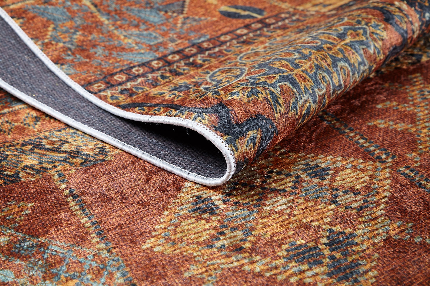 A close-up of the Ancient Palace - Washable Rug - JR1864 (Custom Size) in orange, showing its multicolored pattern and textured gray underside—an ideal choice for high-traffic spaces.