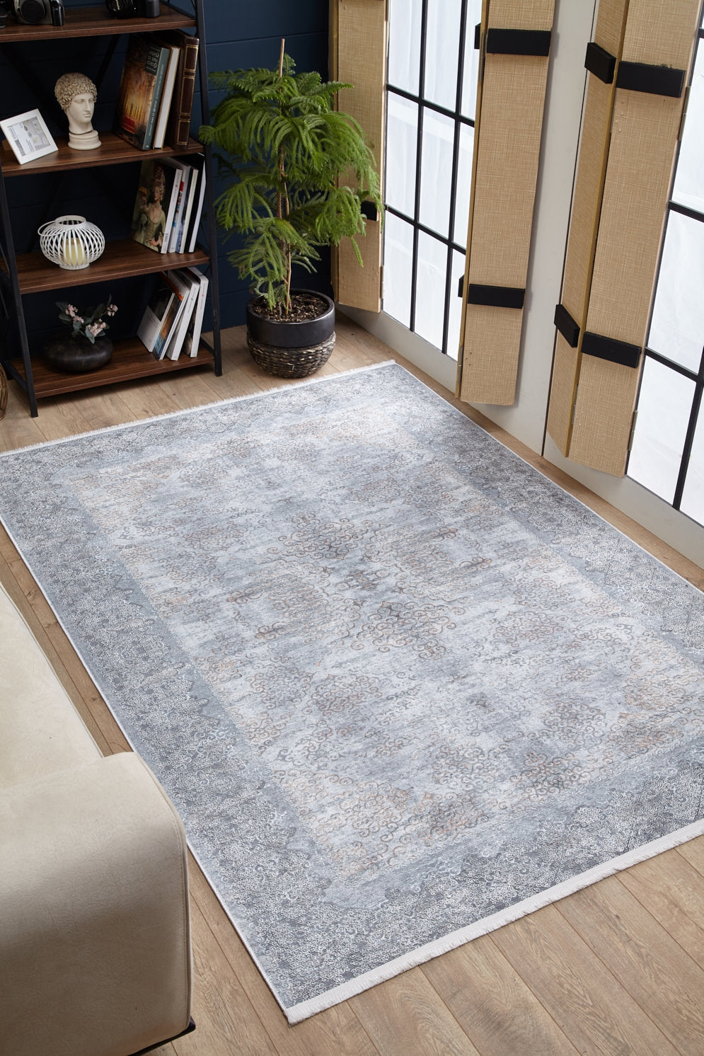 The Ancient Treasure - Washable Rug - JR1785 (Custom Size) in light gray adds style to a cozy living room with a beige sofa, potted plant, bookcase, and tall windows—perfect for high-traffic areas.