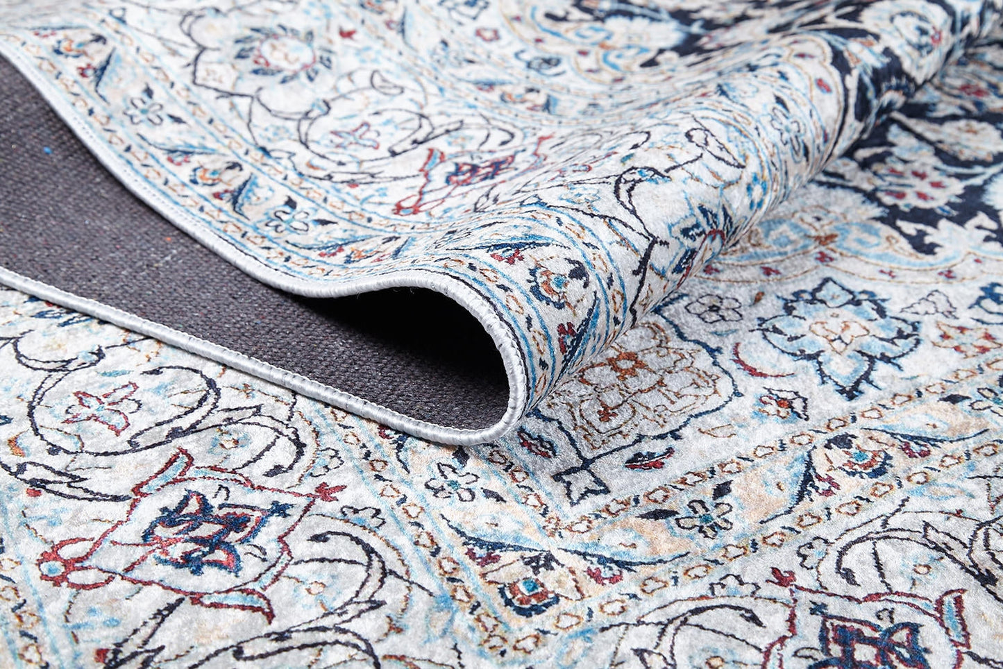 A close-up of the Antique Enchantment - Washable Rug - JR1686 (Custom Size) displays its light, intricate floral and geometric flat weave pattern with a flipped corner revealing the dark textured backing.