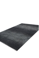 The Antrachite Shadows Black Rug - M497A is a large, rectangular, machine-made rug with a textured, slightly speckled surface, displayed against a white background.