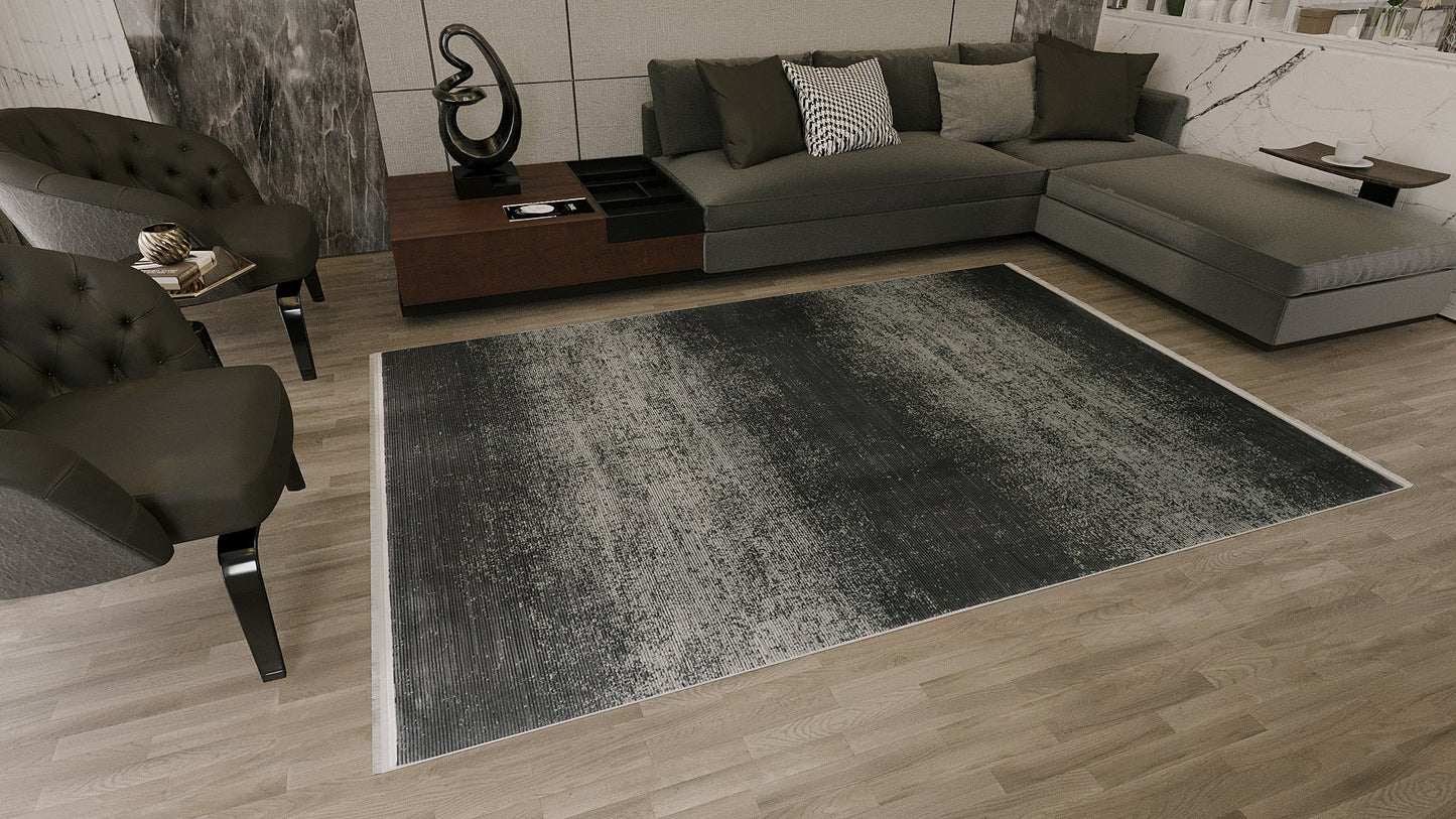 Modern living room with gray sectional, dark accent chairs, decorative pillows, wall art, a black abstract sculpture on a wooden side table, and the Antrachite Shadows Black Rug - M497A on light wood flooring.