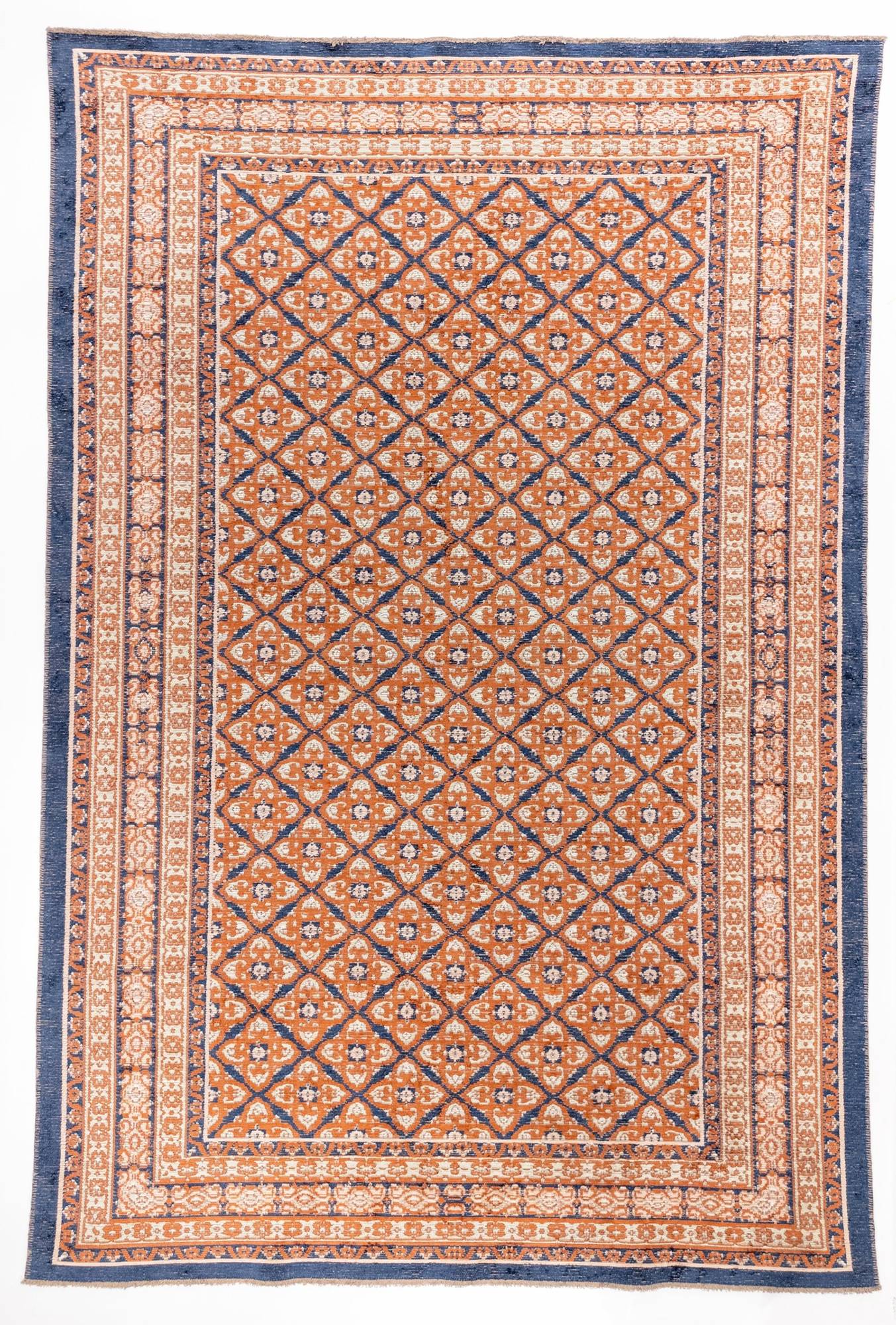 Spice Lattice area rug with rust orange field, cream diamond lattice pattern, and navy blue triple border