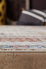 Close-up side view of the Archery Elegance Premium Rug - Earthy - 2183B, featuring a thin, colorful modern design on a wooden floor, with blurred cushions and home decor in the background.