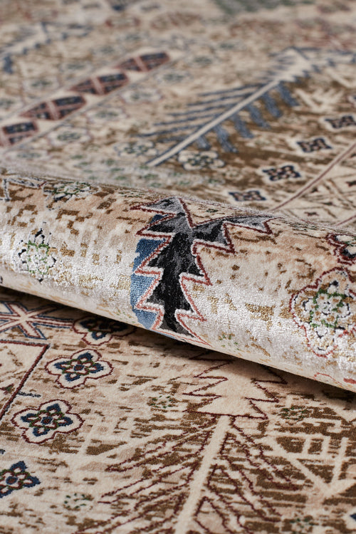 Bild 1 in Galerieansicht laden. A close-up of the Archery Elegance Premium Rug - Earthy - 2183B, a machine-made rug featuring intricate geometric and floral patterns in beige, brown, black, and blue tones, partially rolled up to highlight its texture and detail.