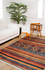 A cozy living room features the Arctic Chill - Washable Rug - JR860 (Custom Size), ideal for high-traffic areas, along with a white sofa, potted plant, orange decorative horse, vintage radio on a wooden stand, and bright natural light.