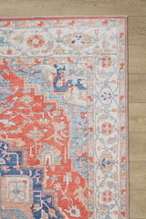 A close-up of the Ardentis Medallion Washable Rug - LCC3002 (Outlet) US, featuring colorful floral and geometric patterns in red, blue, beige, and white on a light wooden floor.