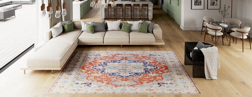 Bild 1 in Galerieansicht laden. Modern open-plan living room with light wood floors, a large beige sectional sofa, green and white throw pillows, the Ardentis Medallion Washable Rug - LCC3002 (Custom Size) in red multicolor, and a kitchen in the background.