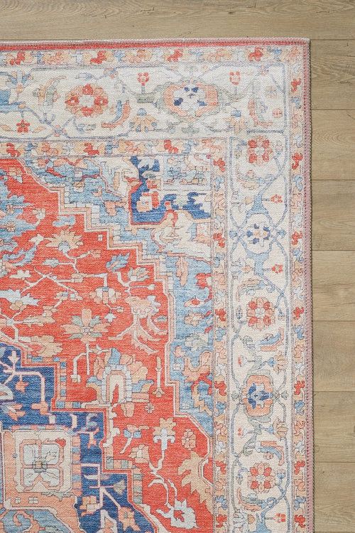 Bild 1 in Galerieansicht laden. A close-up of the Ardentis Medallion Washable Rug - LCC3002 (Custom Size), featuring vibrant red, blue, and ivory floral and geometric motifs on a flat weave, displayed on a light wooden floor.