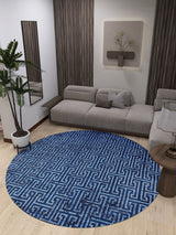 A modern living room with a gray sectional, light wood floors, wall art, a mirror, potted plant, a small round side table, and the Art Deco Elegance - Washable Rug - JR1224 (Custom Size), ideal for high-traffic areas.
