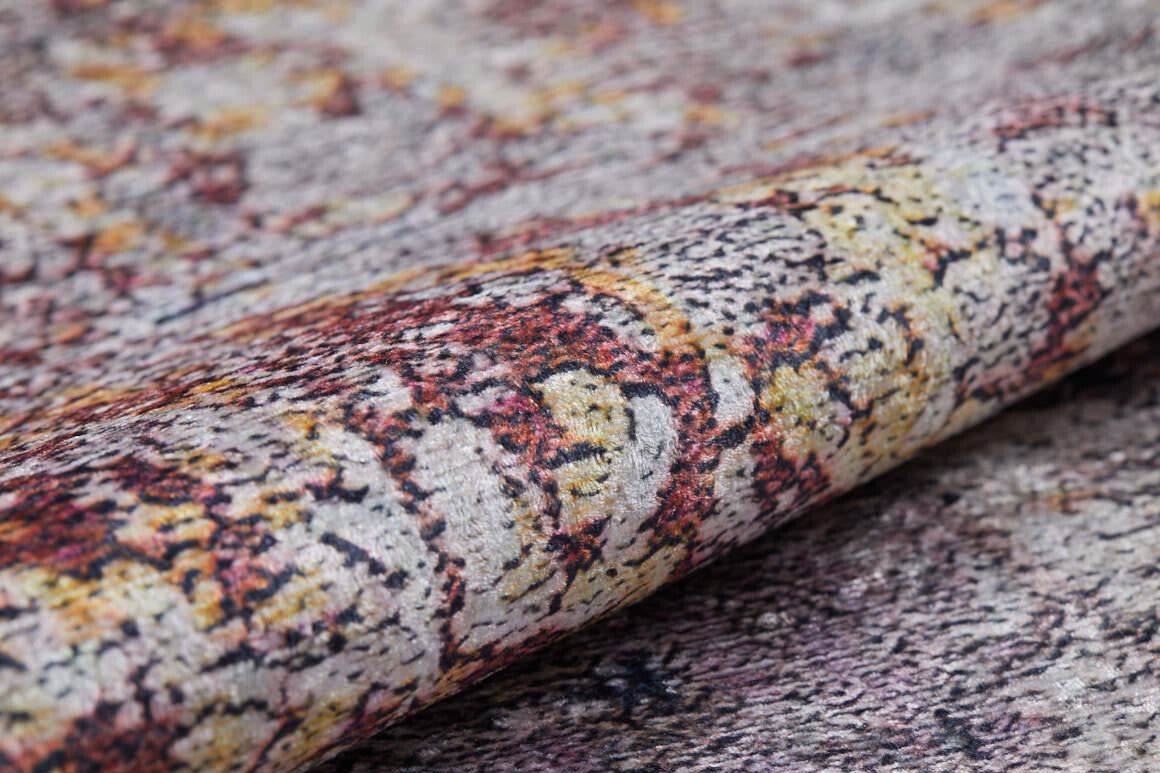 A close-up of the Artistic Abstraction - Washable Rug - JR775 (Custom Size) shows its textured, allergy-friendly surface and abstract design in grey, yellow, and muted red, with the rug slightly rolled to highlight its intricate pattern.