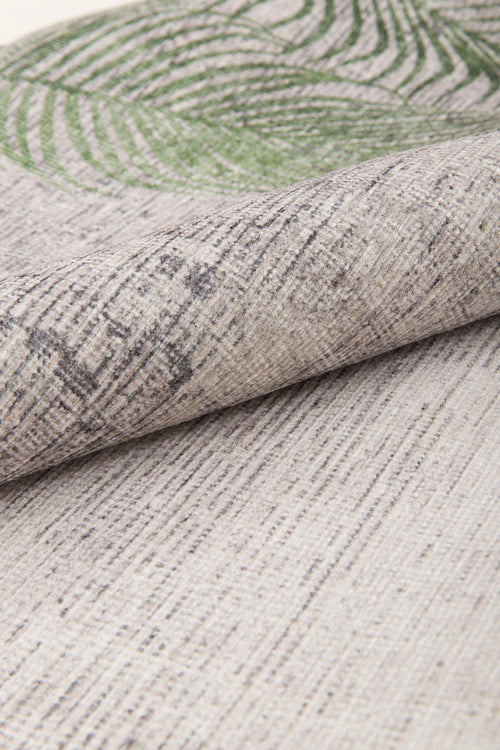 Bild 1 in Galerieansicht laden. A close-up of the Ashwing Silence - Washable Rug - JR0048 shows textured beige fabric with thin, uneven dark lines and a green leaf pattern partially visible at the top edge.