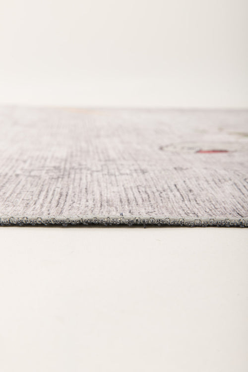 Bild 1 in Galerieansicht laden. Close-up side view of the Ashwing Silence - Washable Rug - JR0048, featuring a thin, light-colored textured surface with subtle patterns on a neutral background. The edge is in focus, showcasing its low-profile design.