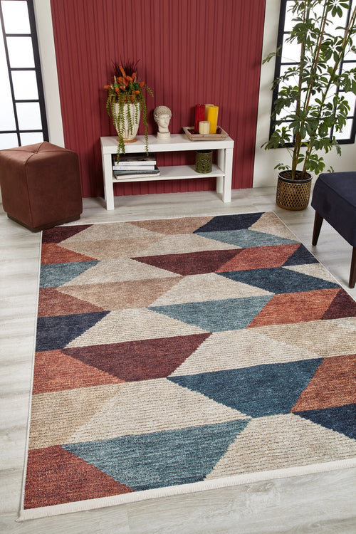 Load image 1 in gallery view. A modern living room features the Asymmetrical Wonder - Washable Rug - JR1725 (Custom Size) with bold geometric patterns in blue, beige, rust, and brown—ideal for high-traffic areas—plus a white console table, decor accents, and a red paneled accent wall.