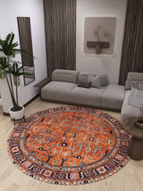 A modern living room with the Aurelius Coral Washable Rug - LCC3005, a light gray sectional, potted plant, wall art, mirrors, and wood accents—perfect for adding style and comfort to high-traffic spaces.