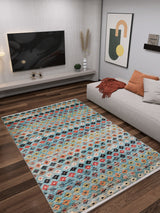 A modern living room with a wall-mounted TV, contemporary art, a beige sectional sofa with gray and rust pillows, and the Aztec Ambience - Washable Rug - JR1086 (Custom Size) for high-traffic areas on dark wood floors.