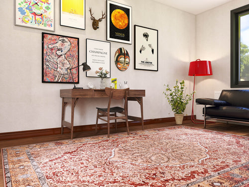 Load image 1 in gallery view. A home office includes a wooden desk, a chair, colorful artwork and framed posters on the wall, a red floor lamp, a plant, and the Baroque Charm - Washable Rug - JRN1016 (Custom Size) beneath a black sofa by a large window.