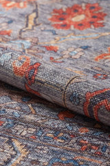 A close-up of the Bellaris Gray Washable Rug - LCC3003 (Outlet) US displays its textured flat weave and intricate red, blue, yellow, and gray patterns.