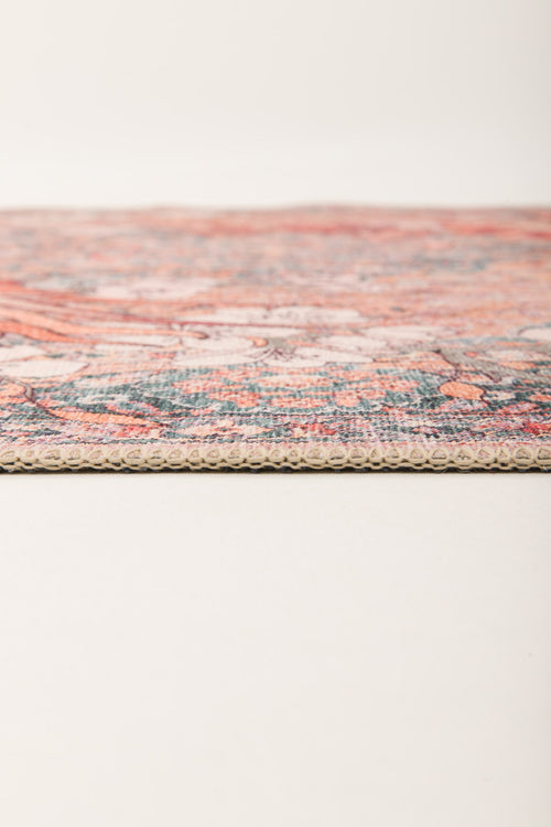 Load image 1 in gallery view. Close-up side view of the Blazefang Myth - Washable Rug (JR0049) featuring a thin, flat weave with a textured edge and vibrant geometric pattern, displayed on a plain light surface against a neutral background.