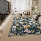 A modern living room with light wood floors, neutral furniture, and the Bloom Garden - Washable Rug - JRN1039 (Custom Size), featuring colorful florals and greenery. A big window with sheer curtains fills the space with natural light.