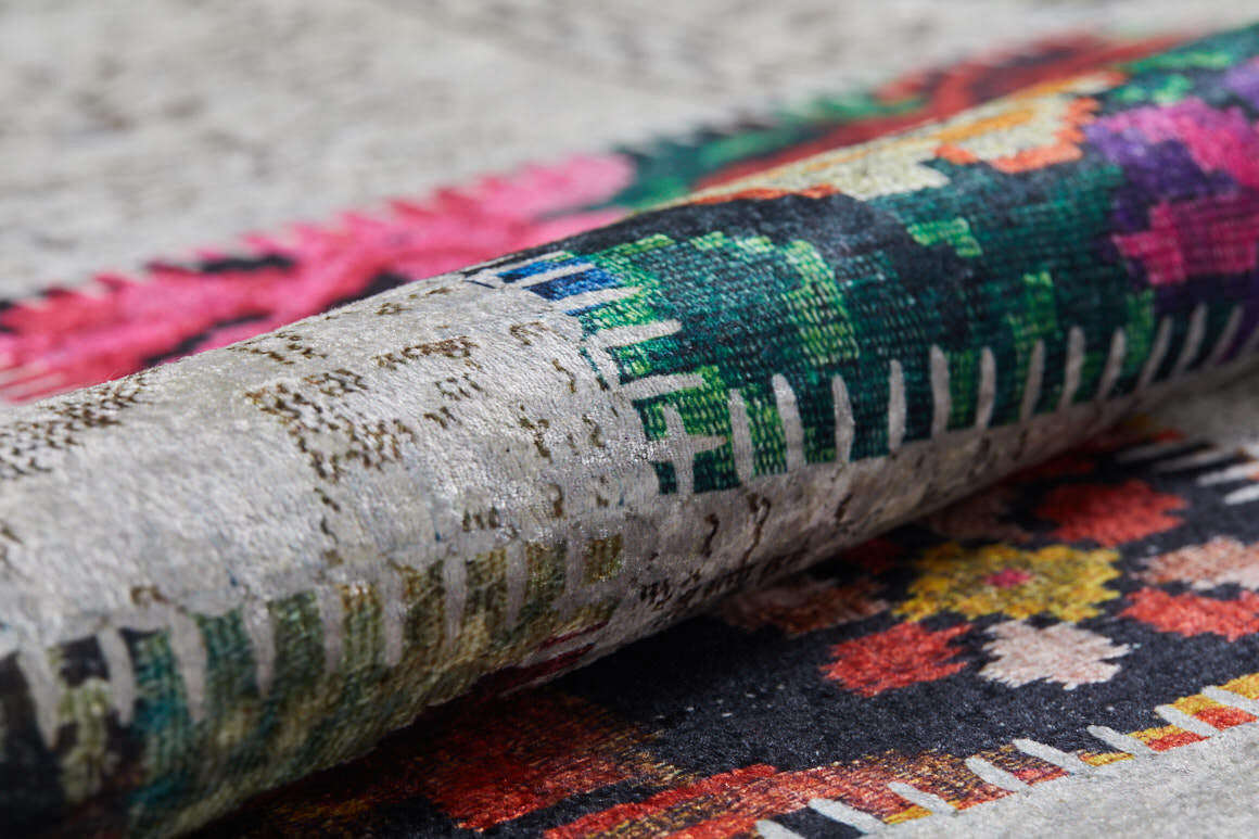 Close-up of the Blooming Paradise - Washable Rug (JR188, Custom Size) rolled up, displaying intricate geometric and floral patterns in green, red, pink, and black on a gray background—ideal for high-traffic areas.