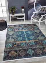A living room with the Blossoming Bazaar - Washable Rug - JR1862 (Custom Size), featuring blue, teal, and gold patterns on a light wood floor, ideal for high-traffic areas, accented by a white chair and dark accent wall.