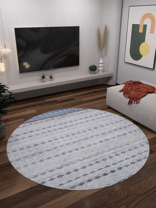 Load image 1 in gallery view. A modern living room with the Bohemian Reverie - Washable Rug - JR1974 in gray-anthracite on wooden floors, a wall-mounted TV, abstract art, plants, and a beige couch with an orange throw—ideal for high-traffic areas.