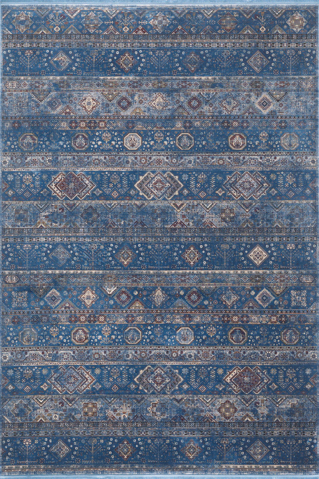 The Bohemian Tracery Rug - Blue - 2221B features a rectangular design with a blue background and detailed geometric and floral patterns in beige, brown, and white, arranged in horizontal rows.