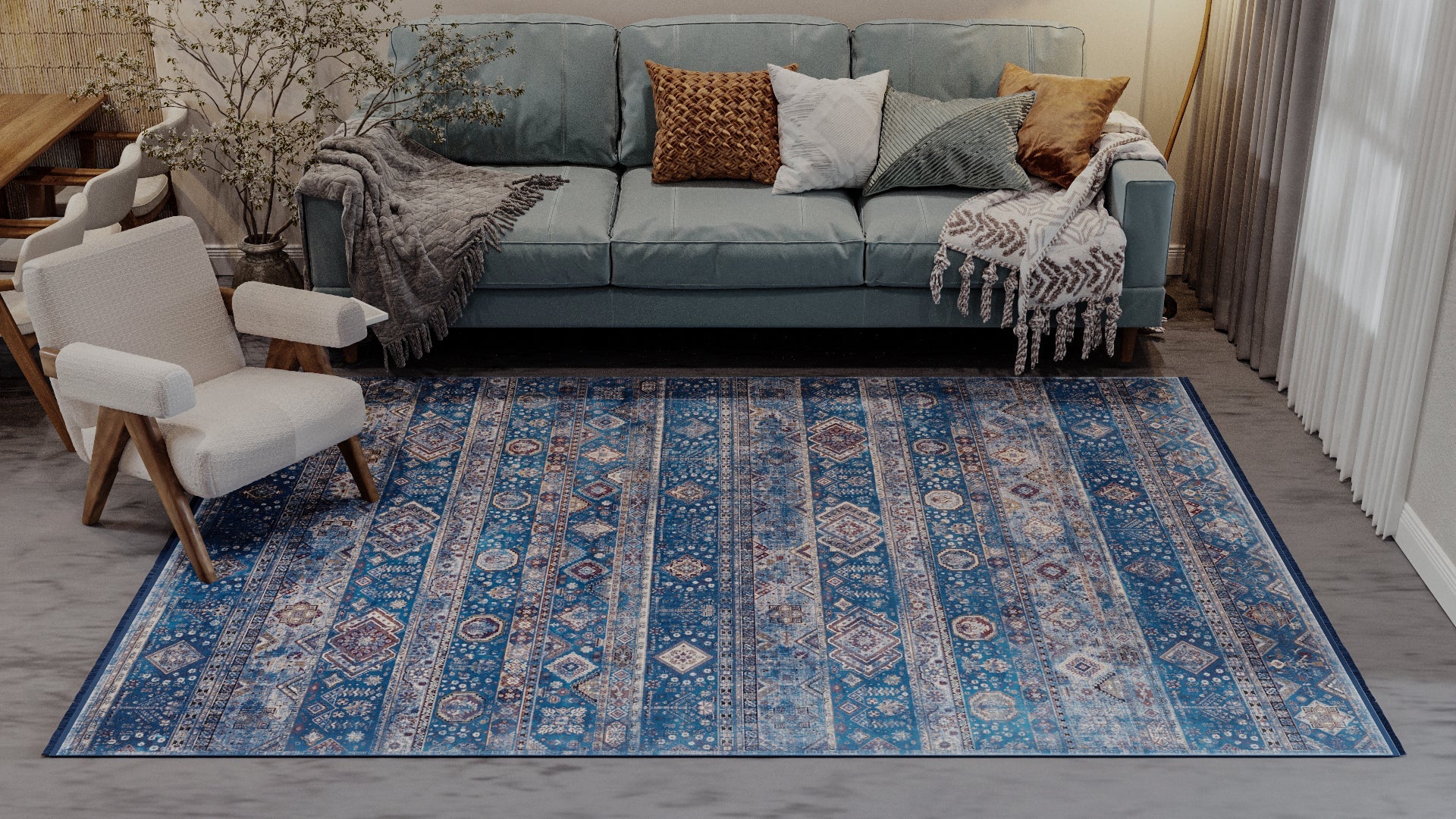 A cozy living room with a light blue sofa, modern cream armchair, pillows and throws, the Bohemian Tracery Rug - Blue - 2221B, and a dining area with chairs and greenery in a vase. Sunlight streams in through the window.