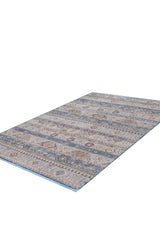 The Bohemian Tracery Rug - Grey - 2221C is a rectangular, machine-made rug featuring muted blue, beige, and brown geometric and floral patterns on a white background. It has a flat-woven texture and serves as a decorative accent.