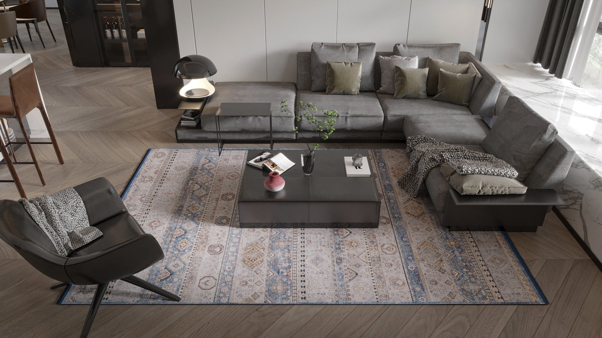 Modern living room with a gray sectional, black lounge chair, Bohemian Tracery Rug - Grey - 2221C featuring geometric traditional patterns, a low black coffee table with books and a vase, and soft neutral tones throughout.