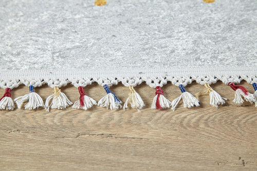 Load image 1 in gallery view. Close-up of the Boho Chic - Washable Rug - JR5103 (Custom Size), a light gray flat weave with decorative tassels and red, blue, and beige threads—ideal for high-traffic areas and shown on a wooden floor.