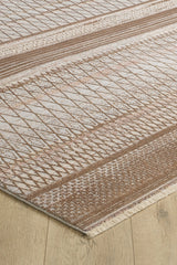 A close-up of the Boho Sunset Trellis Rug - HRD004, a machine-made area rug with beige and brown geometric lines, diamonds, textured sections, and fringed edges, displayed on a light wood floor.