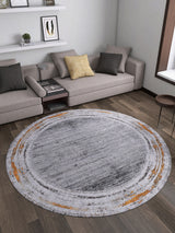 A modern living room with beige sectional sofas, accent pillows, wooden flooring, a small side table, shelves on a white wall, and the Bold and Chic - Washable Rug - JR1198 in gray, white, and orange—ideal for allergy-sensitive spaces.