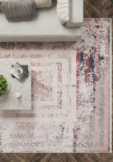 A modern living room with a light gray sofa, white and patterned cushions, a white marble coffee table with a plant, and the Bold and Geometric - Washable Rug - JR1410 in cream, red, and blue—perfect for high-traffic areas—on dark wood floors.