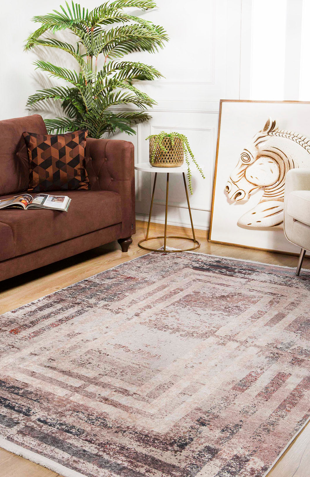 A cozy living room features a brown sofa, geometric pillow, and framed zebra art. The Bold and Geometric - Washable Rug - JR1410 (Custom Size) adds warmth with its bronze and brown tones—ideal for high-traffic wooden floors.