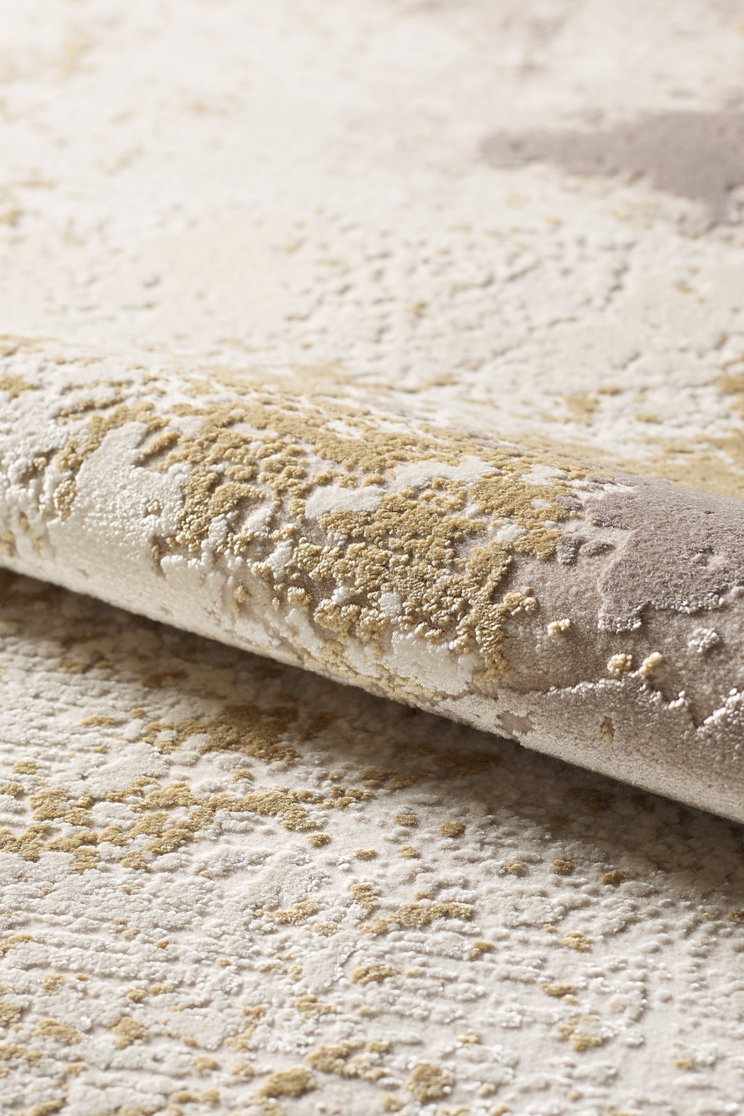 A close-up of the Bright Swirls Contemporary Rug - M657F shows its machine-made cream and beige tones with a raised abstract pattern, creating a soft, tactile surface.