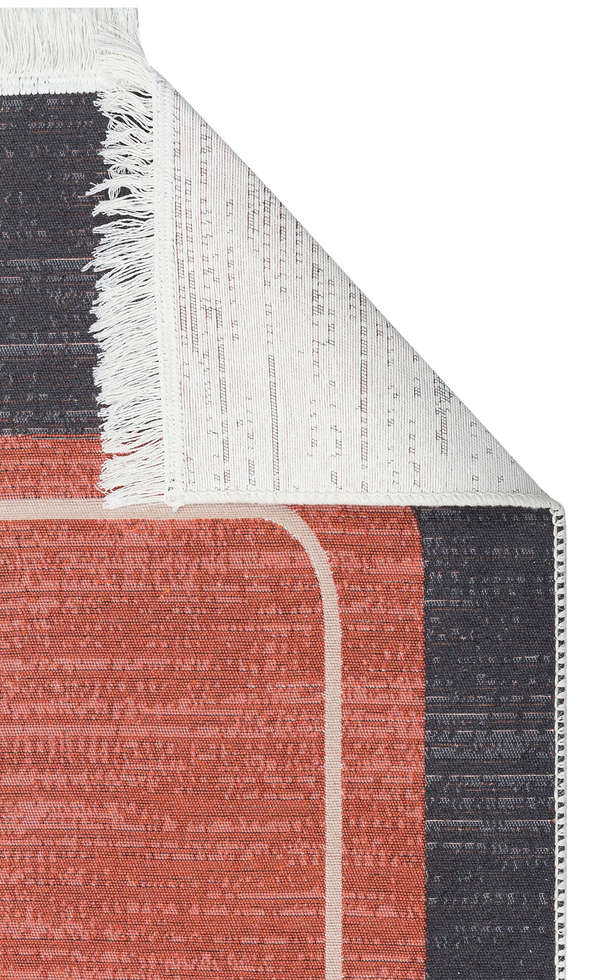 A close-up of the Burnt Stone - Washable Double-Sided Kilims - AR36, showing its red and dark gray geometric pattern with a folded corner revealing the white fringe and underside. Made from recycled cotton.
