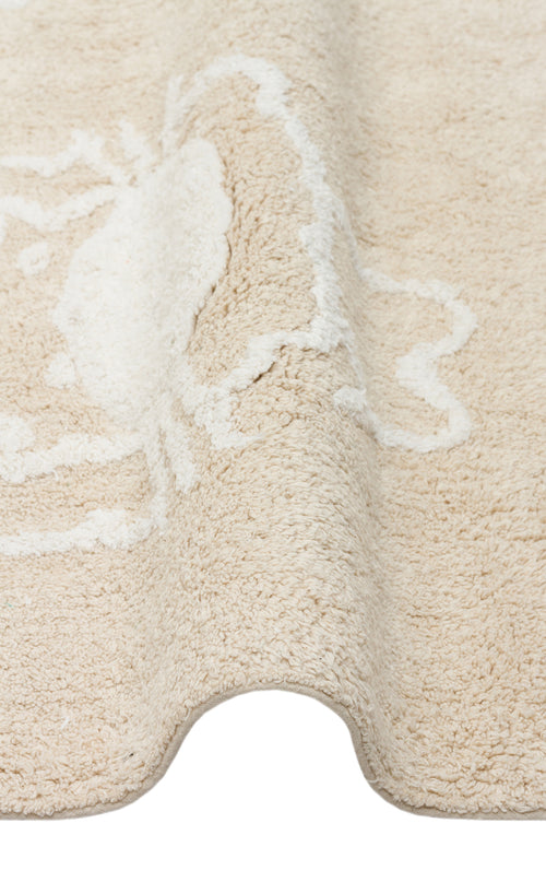 Load image 1 in gallery view. A close-up of the Calm Nest - Washable Shaggy - CBN16 cream beige rug, featuring a subtle white crab design and ultra-soft cotton texture, displayed with a gentle wave in the fabric.