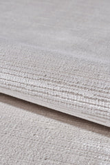 A close-up of the Candlelight Comfort Modern Ivory Rug - EW2824 showcases its soft, textured surface with subtle horizontal lines—an elegant neutral beige rug ideal for enhancing any room’s decor.