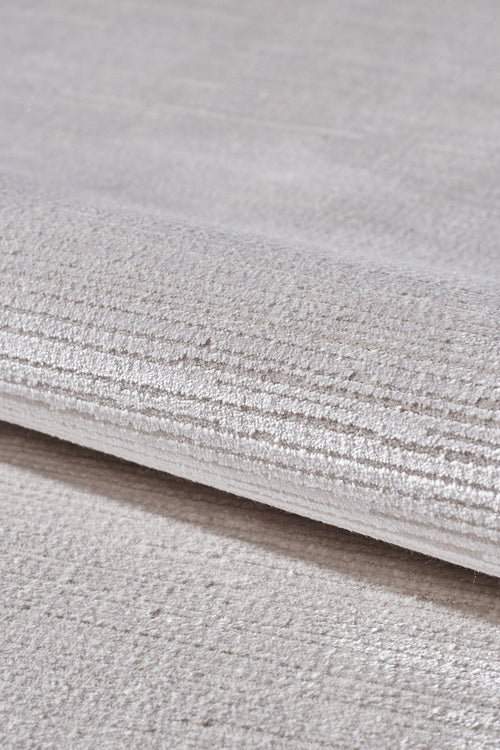 Load image 1 in gallery view. A close-up of the Candlelight Comfort Modern Ivory Rug - EW2824 showcases its soft, textured surface with subtle horizontal lines—an elegant neutral beige rug ideal for enhancing any room’s decor.