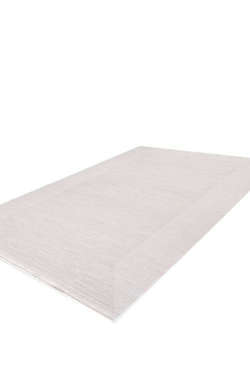 Load image 1 in gallery view. The Candlelight Comfort Modern Ivory Rug - EW2824 is a rectangular, machine-made rug in a neutral hue, featuring a subtle border. Shown angled on a white background to display its texture and thin profile.