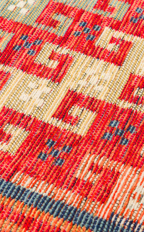 Bild 1 in Galerieansicht laden. Close-up of the Canyon Shade - Washable Reversible Kilim - NMD11, featuring a vibrant red, yellow, white, and blue geometric tribal pattern. Its detailed texture is visible, making it a practical choice for high-traffic areas.